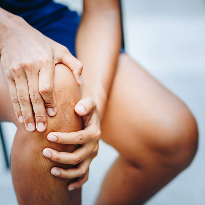 Person fasst sich an Knie