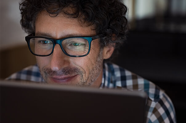 Mann mit Brille vor Laptop